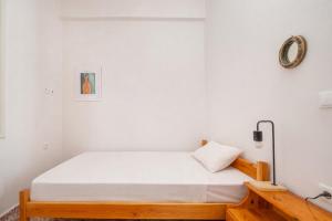a bed in a room with a white wall at Dafni Local Style, 1 Min from Main Beach in Kardamaina +15 photos