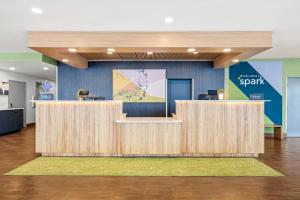 an office lobby with wooden reception desks and a bench at Spark by Hilton Pelham Birmingham I 65 in Pelham