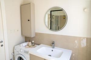 a bathroom with a sink and a washing machine at The Wave Seafront Apartment Vis in Vis