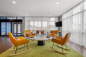 a waiting room with chairs and a table and a tv at Spark by Hilton Pelham Birmingham I 65 in Pelham