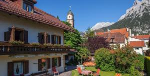 a group of buildings with a clock tower in the background at Ferienhaus Spornitz in Mittenwald