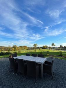 a table and chairs with a view of a field at Le Daguet pour 8 in Florenville