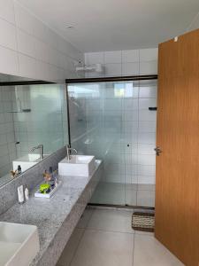a bathroom with two sinks and a glass shower at Casa Ville Perignon in Gravatá +12 photos