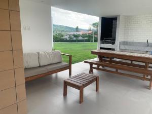 a living room with two benches and a table at Casa Ville Perignon in Gravatá