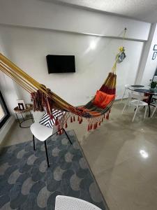 a hammock in a room with a table and a tv at Estudio con Increíble VISTA AL MAR de 1 a 4 huespedes in Porlamar