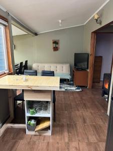 a living room with a table and a couch at Cabaña Centro in Coihaique