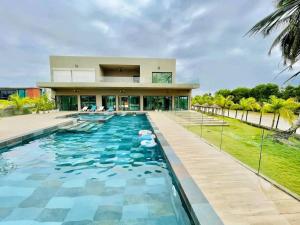 a swimming pool in front of a house at villa rach in Assinie