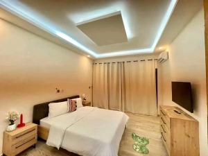 a bedroom with a bed and a television in it at villa rach in Assinie