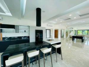 a kitchen with a large black counter and stools at villa rach in Assinie