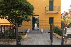 a yellow building with a gate and a door at Appartamento Laghetto in Segrate