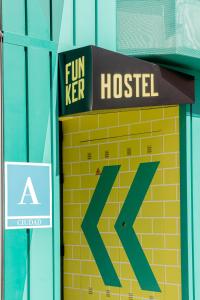 a sign that reads fun keep hospital on a brick wall at Funker Hostel in Málaga