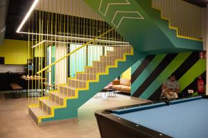 a man sitting in a room with a pool table at Funker Hostel in Málaga