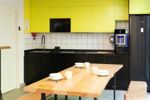 a wooden table in a kitchen with yellow cabinets at Funker Hostel in Málaga +33 photos