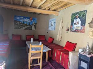 a room with a couch and a table with red pillows at Auberge Restaurant Oumidou in Agoudal