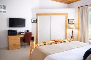 a bedroom with a bed and a desk with a television at Lodge Room 002 in Black Butte Ranch +5 photos