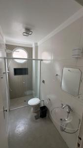 a bathroom with a toilet and a shower and a sink at Apê Completo - 300m da Praia in Guarujá +6 photos