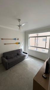 a living room with a couch and a window at Apê Completo - 300m da Praia in Guarujá