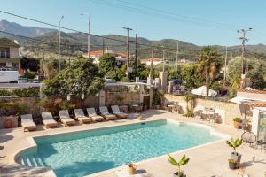 a swimming pool with lounge chairs and a pool at Aroma Villa & Studios in Limenas