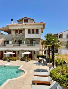a resort with a swimming pool and a building at Aroma Villa & Studios in Limenas