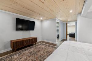 a bedroom with a bed and a television on the wall at Mt Rushmore Duplex in Rapid City