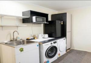 a kitchen with a washing machine and a sink at Stylish Tawa Retreat in Wellington