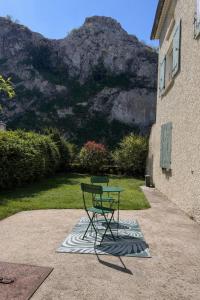 a table and a chair in front of a building at Le Petit Rocher in Pierrelatte