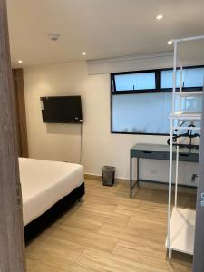 a bedroom with a bed and a flat screen tv at Eurolan 72 in Bogotá