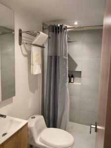 a bathroom with a toilet and a shower curtain at Eurolan 72 in Bogotá