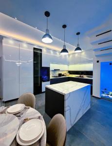 eine Küche mit zwei Tischen und einer Theke mit Stühlen in der Unterkunft Cresent Homes in Accra