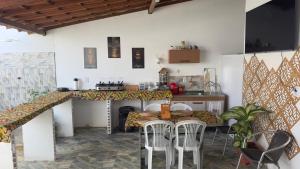 a kitchen with a table and chairs in a room at SR Hotel e Pousada Pirambu in Pirambu