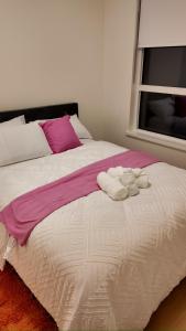 a bedroom with a large bed with towels on it at Central Luxe in Surrey
