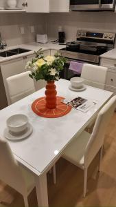 a white table with a vase of flowers on it at Central Luxe in Surrey