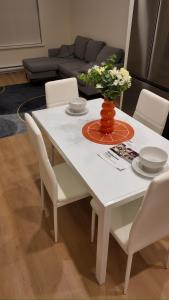a white table with white chairs and a vase with flowers at Central Luxe in Surrey