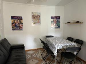 a living room with a table and a couch and posters at Hostal Vaihere in Hanga Roa