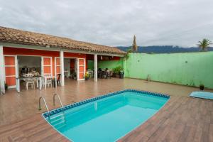 a swimming pool in front of a house at Pousada da Sú in Bertioga