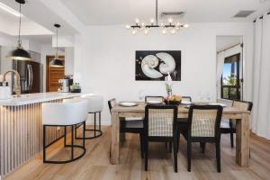 a kitchen and dining room with a wooden table and chairs at New Sunset Villa Ocean Side Lanai Pool Kings in Waikoloa
