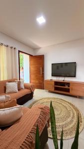 a living room with a flat screen tv on a wall at Espaço Move in Porto Seguro