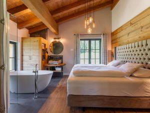 a bedroom with a large bed and a bath tub at Tauernlodge Wagrain Edelweiss 42E in Wagrain