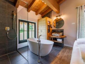 a bathroom with a tub and a shower at Tauernlodge Wagrain Edelweiss 42E in Wagrain +46 photos