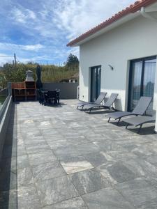 a patio with chairs and a table on a house at Achada de Gaula House in Gaula