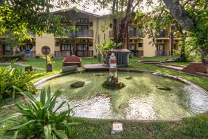 a koi pond in front of a building at Portobello Praia in Porto Seguro