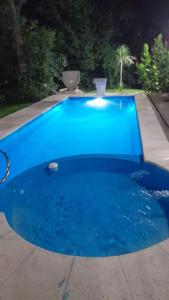 a large blue swimming pool in a yard at Cabaña LA SOÑADA in Villa Anizacate +6 photos