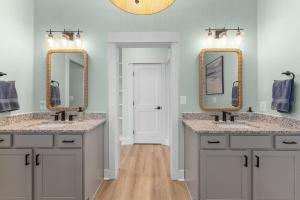 a bathroom with two sinks and two mirrors at Bay Dreaming in Montross +23 photos
