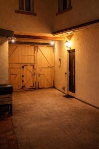an empty room with two wooden garage doors at night at Elohan Suite, parenthèse chic & cosy in Pontoise