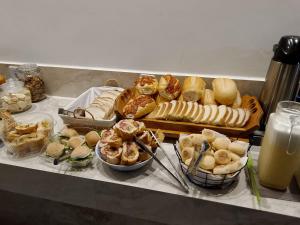 a buffet with various types of bread and pastries at Hotel Arara Azul in Pontes e Lacerda