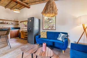 a living room with a blue couch and a refrigerator at ALDEA DEL MAR by Villa del Sol in Máncora