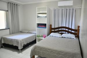 a bedroom with two beds and a book shelf at Pousada Bem-te-vi in Aracaju +191 photos