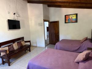 a bedroom with two beds and a tv on the wall at Hotel del Pozo in San Sebastián del Oeste