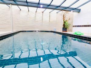 a large swimming pool with blue tiles in a building at Le Congo in Ochamps