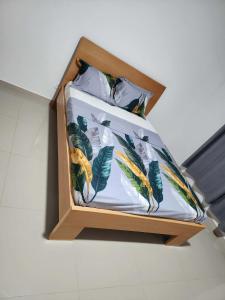 a bed with a wooden frame with leaves on it at Soares Stay in Tarrafal